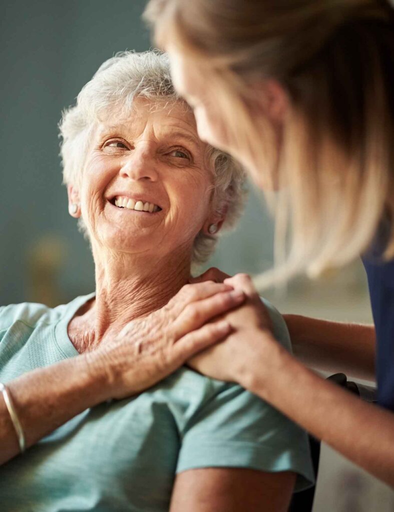 Grateful looking older woman smiling at a caring helper